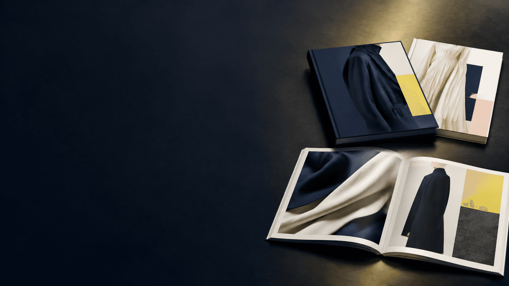 Open fashion lookbook and closed printed copies arranged in a studio
