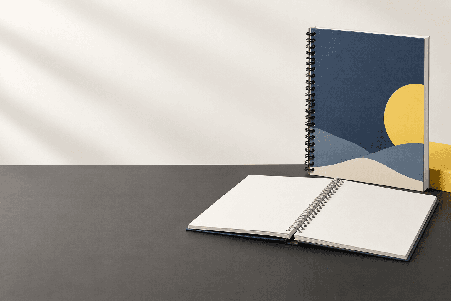 Upright and open spiral-bound books with continuous coils on the right of a studio scene