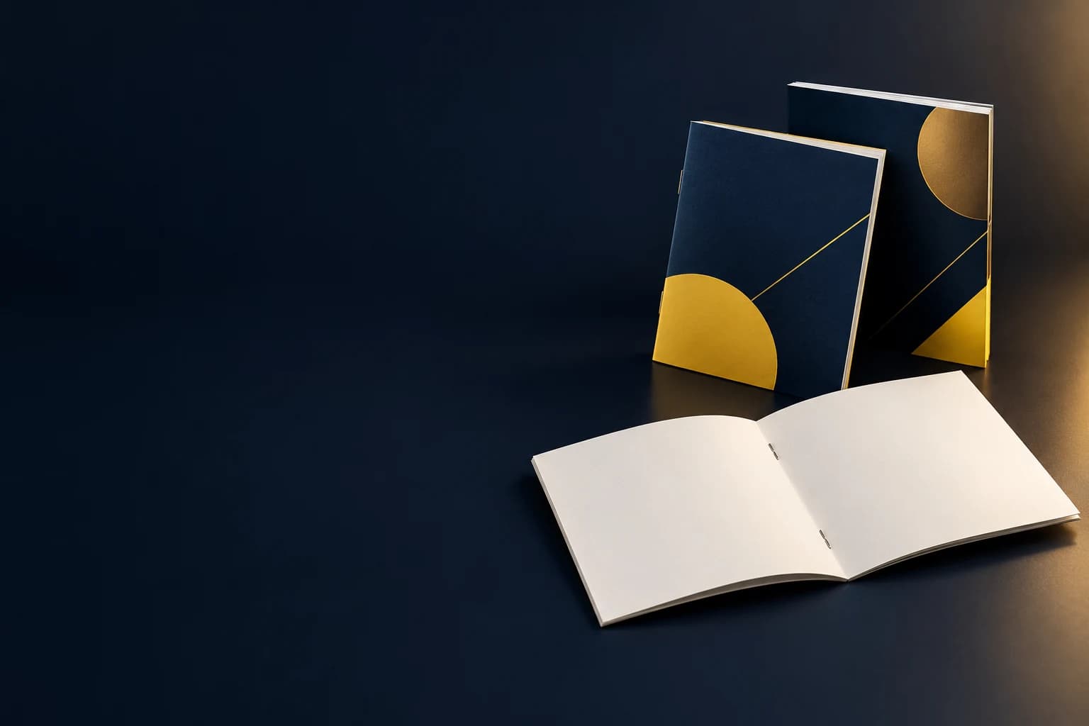 Illustrative saddle-stitched books with a slim folded spine and two staples at the center spread