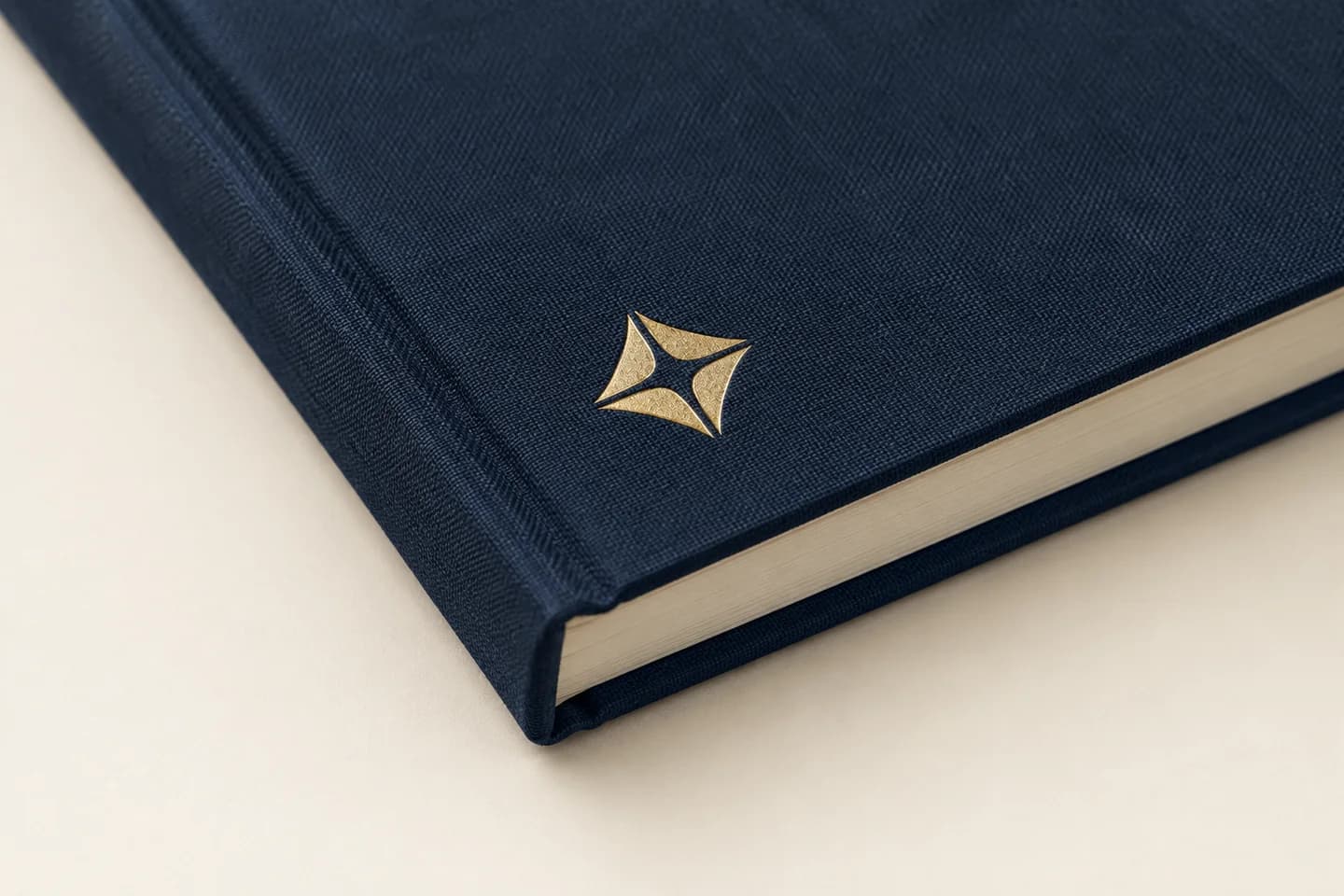 Navy cloth-wrapped hardcover corner with a geometric gold foil detail